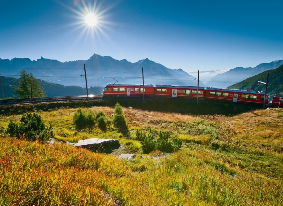 A train travels up a mountain through the Alps