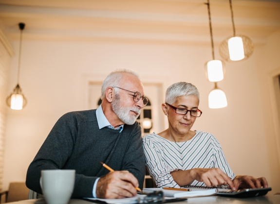 Mature couple doing some paperwork and calculations at home