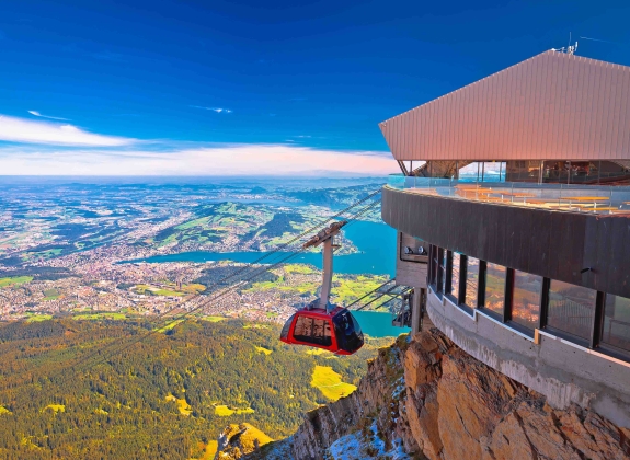 A Gondola approaches the terminal with mountain views in background