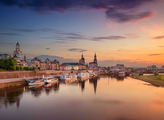 Panoramic cityscape image of Dresden, Germany with reflection of the city in the Elbe river, during sunset.
