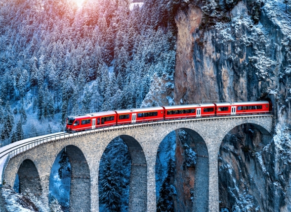 Aerial view of Train passing through famous mountain in Filisur, Switzerland. train express in Swiss Alps snow winter scenery.