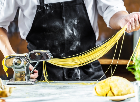 chef folding and flattening pasta