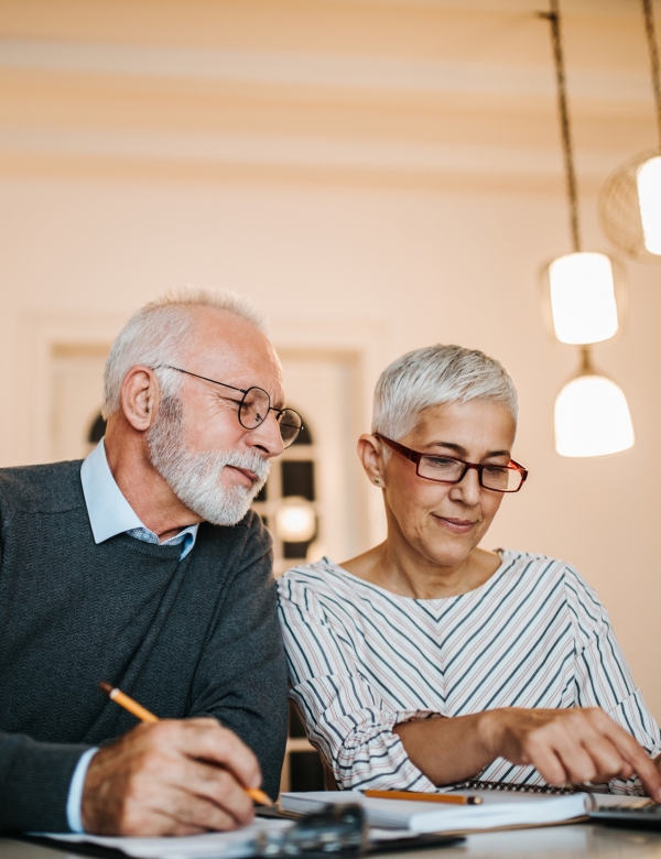 Mature couple doing some paperwork and calculations at home