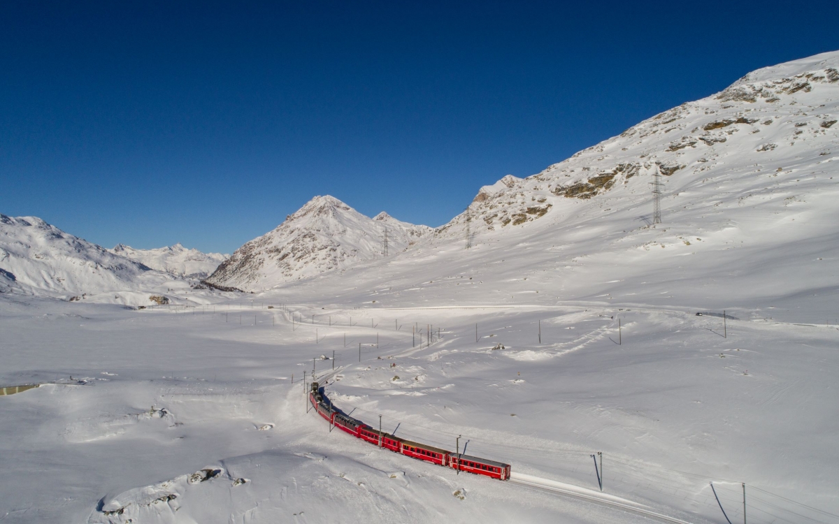 The Bernina Express A train travels through a vast snowy landscape