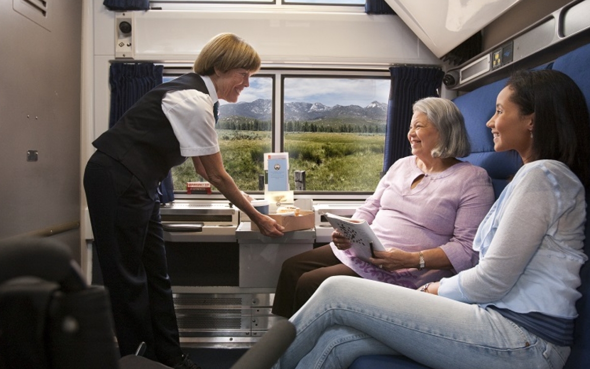 friends relaxing and being catered to in Amtrak's accessible bedroom