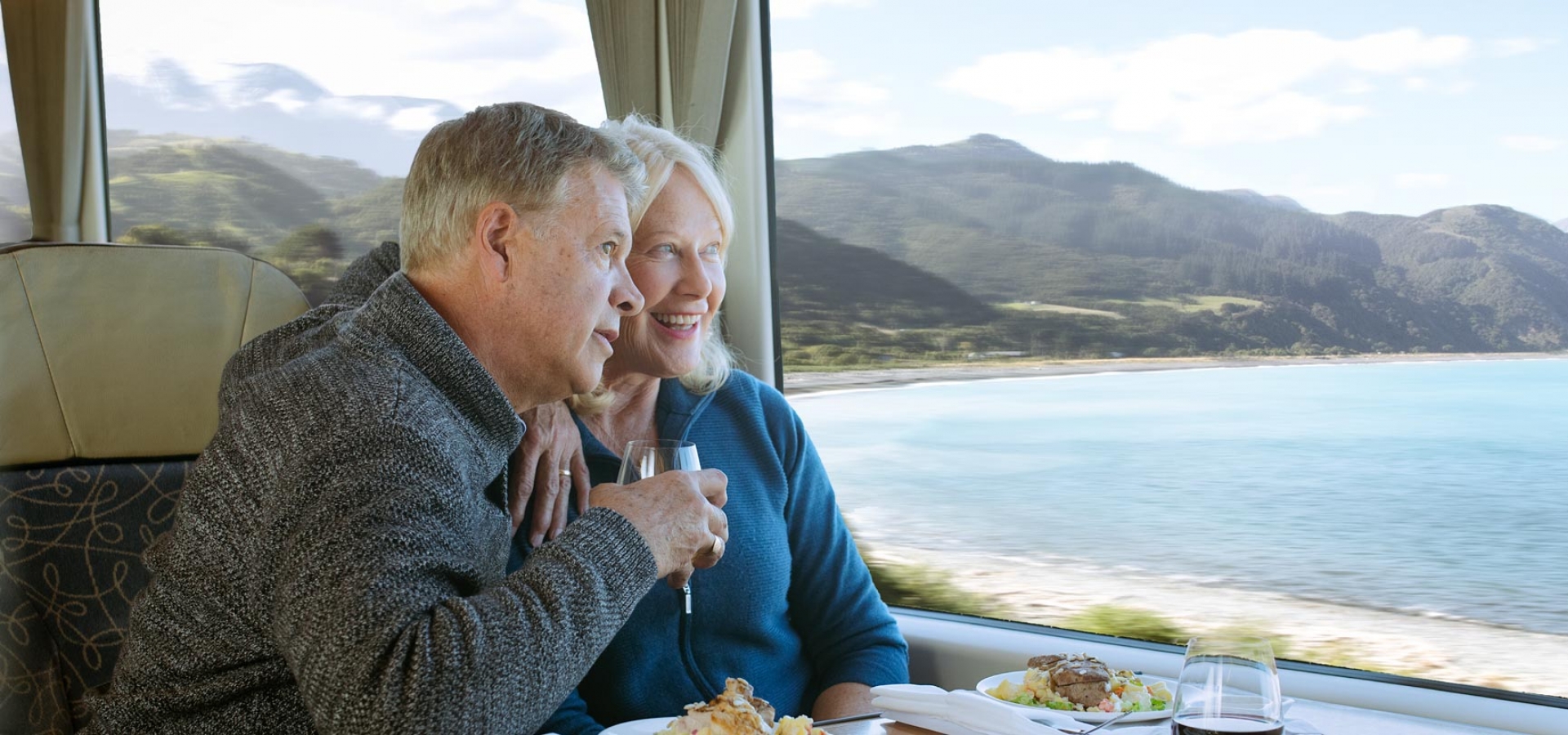 couple eating in the scenic plus class and looking at ocean onboard the coastal pacific