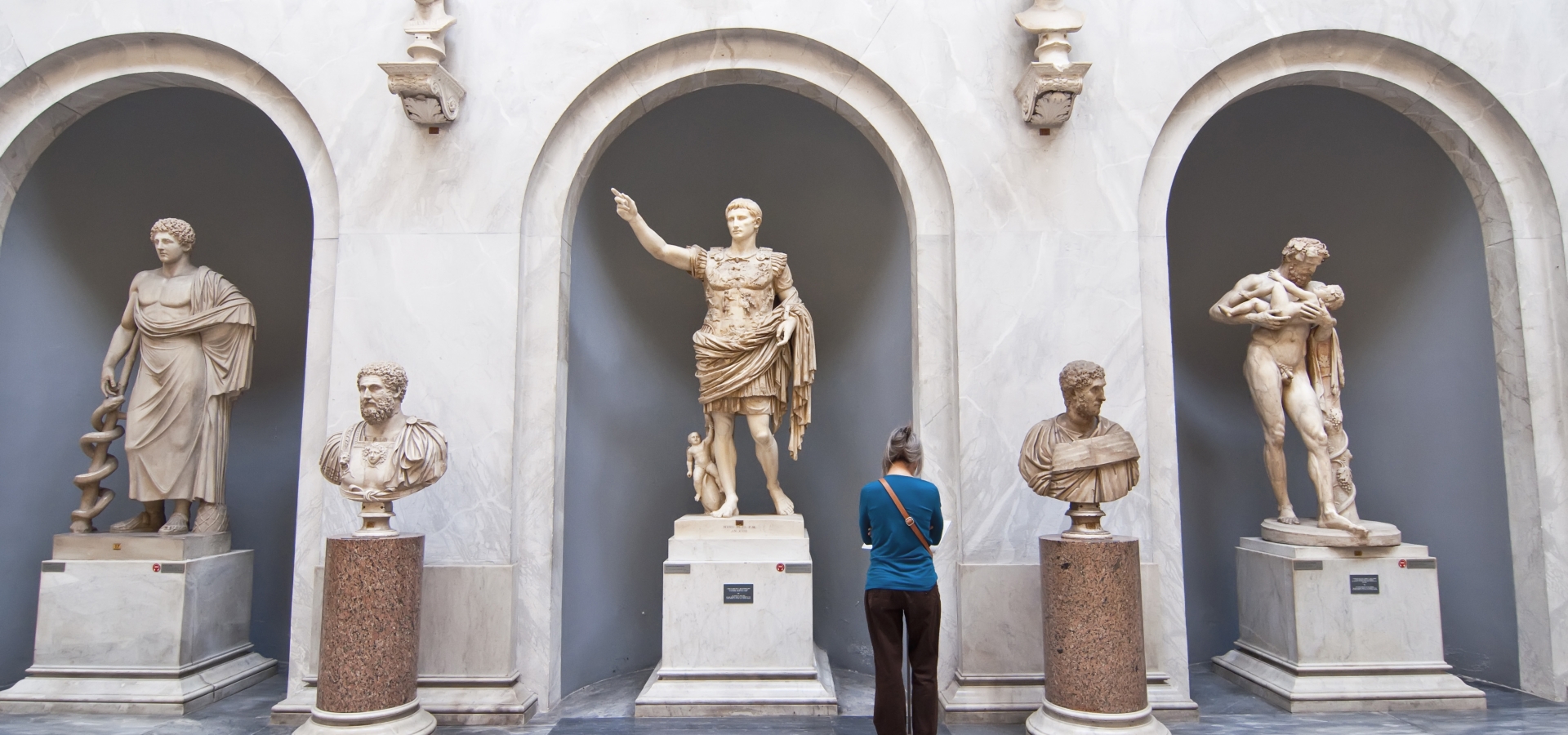 Tourists visiting the statues in the halls of the Vatican Museums in Rome, Italy