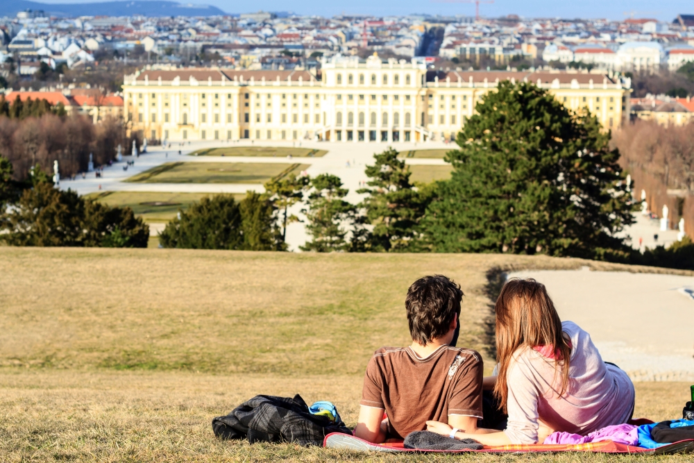 romantic couple laying on the hill with the view on Schonbrunn palace in Vienna, Austria.