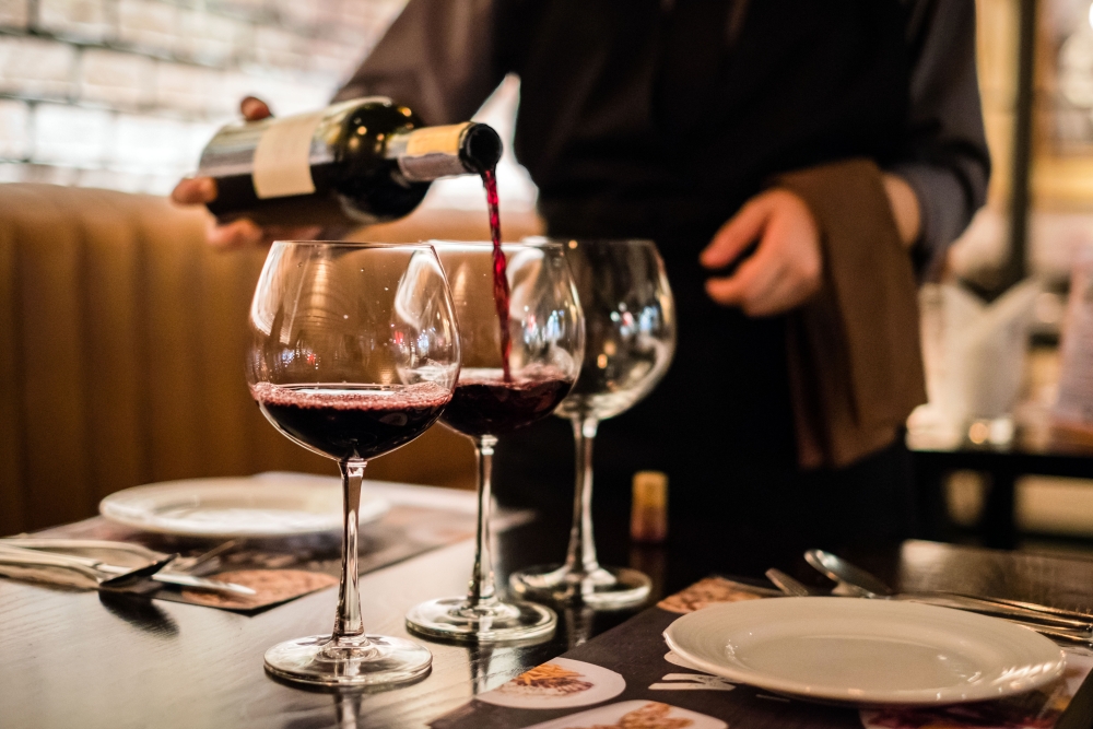Red wine pouring into wine glass, close-up